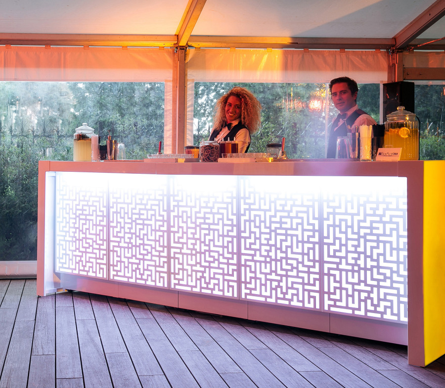 Weiße Cocktailbar mit Sonderdesign - gelasterte Frontkästen mit Beleuchtung.