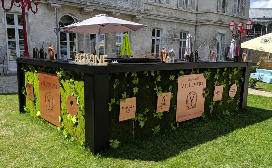 Mobile Cocktailbar im freien mit Moos-bedeckten Verkleidungsteilen.