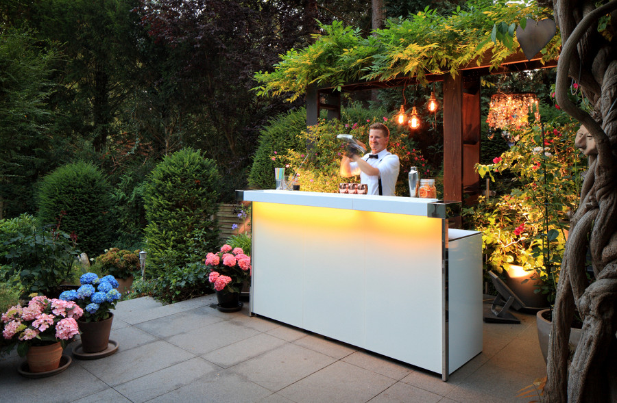 Weiße Cocktailbar mit Beleuchtung in modernem Garten-Ambiente